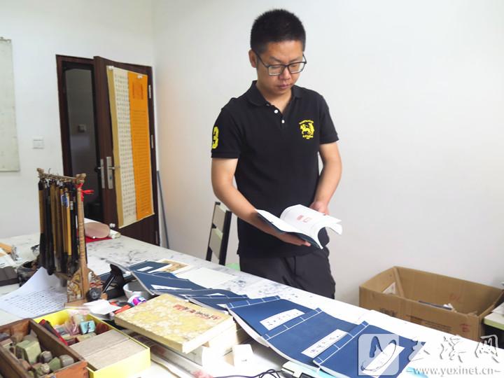 高源鸿翻阅自己的印谱。