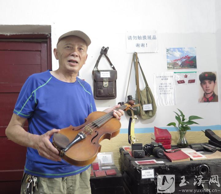 何志军展示他与兄长于20世纪60年代购买的小提琴。