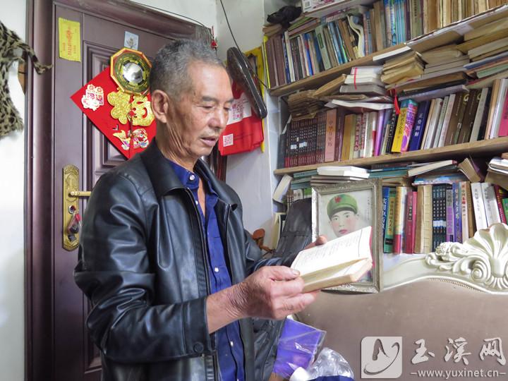 张玉祥翻看40多年前熊桂英赠给他的民歌笔记本。